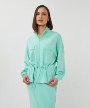 Load image into Gallery viewer, Woman wearing a mint green outfit against a plain background.
