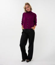 Load image into Gallery viewer, Woman wearing a purple sweater cardigan over matching sleeveless turtleneck, black pants and black shoes against a white background.