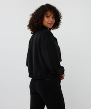 Load image into Gallery viewer, Woman wearing a black jacket and black pants against a white background.