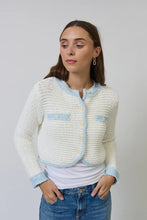 Load image into Gallery viewer, Woman wearing a white textured sweater with light blue contrast stitching and blue jeans on a plain background.