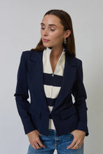 Load image into Gallery viewer, Woman wearing a navy blazer with a striped dickey and blue jeans against a plain background.