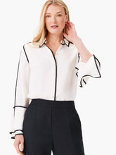 Load image into Gallery viewer, This stunning and unique blouse is a bold choice for fashion lovers who like to stand out. The black trim along the seams creates a striking contrast with the off-white fabric. The pearl buttons add a touch of elegance, while the flounce sleeves have slits at the end for extra flair. The blouse has a classic shirt collar and a hip-length hem.