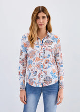 Load image into Gallery viewer, Woman wearing a floral blouse and jeans against a light gray background.