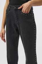 Load image into Gallery viewer, Close-up of model wearing dark grey studded jeans against a white background.