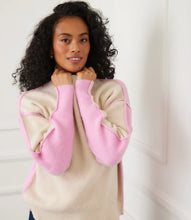 Load image into Gallery viewer, Woman wearing a sand and pink colorblock sweater and jeans against a white wall.