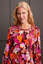 Load image into Gallery viewer, Steal the spotlight in this vibrantly printed blouse cut from flowy challis fabric with a hint of stretch. The popover v-neck, highlighted by delicate fabric ties, features a shirttail hem and long sleeves with elastic cuffs, completing the design. It seamlessly adds sophisticated style and vibrant color to your ensemble.