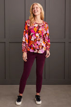 Load image into Gallery viewer, Steal the spotlight in this vibrantly printed blouse cut from flowy challis fabric with a hint of stretch. The popover v-neck, highlighted by delicate fabric ties, features a shirttail hem and long sleeves with elastic cuffs, completing the design. It seamlessly adds sophisticated style and vibrant color to your ensemble.