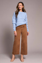 Load image into Gallery viewer, Woman wearing a light blue sweater. brown pants and tan boots against a neutral background.