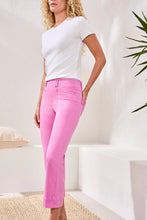 Load image into Gallery viewer, Woman wearing a white t-shirt and pink pants standing in a room with a plant.