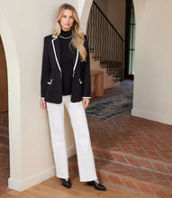 Load image into Gallery viewer, Woman in a black blazer with cream trim, cream pants and black flats standing in an indoor setting.
