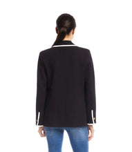 Load image into Gallery viewer, Model wearing a black blazer with cream trim and blue jeans against a white background.