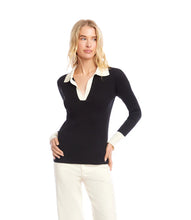 Load image into Gallery viewer, Woman wearing a black sweater with white collar and cuffs and white pants against a white background.