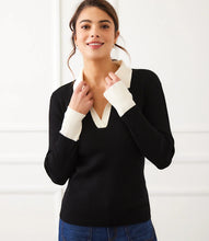 Load image into Gallery viewer, Woman wearing a black sweater with white collar and cuffs and jeans against a white background.