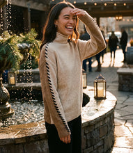 Load image into Gallery viewer, A woman laughing outdoors in front of a stone fountain, wearing a color block sweater with black contrast stitching down the sleeves and black pants.