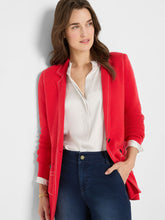 Load image into Gallery viewer, Woman wearing a red blazer over a white shirt and blue jeans against a light gray background.