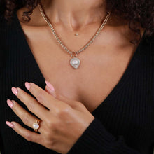 Load image into Gallery viewer, A close-up of a model wearing a gold chain necklace with a tear drop shape pendant set with clear stones, paired with a matching gold ring on her finger.