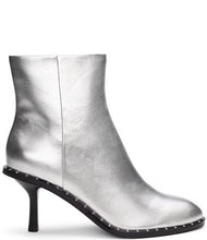 Load image into Gallery viewer, Make a fashion statement with these round-toe ankle boots. Adorned with a dazzling silver metallic color, studded detailing, and a robust stiletto heel, these boots add a dash of urban elegance and individual flair to any outfit.