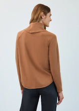 Load image into Gallery viewer, Woman wearing a bronze caramel long-sleeve cowl neck sweater, hoop earrings and dark jeans against a white background.