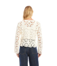 Load image into Gallery viewer, Woman wearing a cream crochet jacket and blue jeans on a white background.
