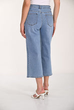 Load image into Gallery viewer, Light blue denim wide-leg jeans and white sandals worn by a model on a white background.