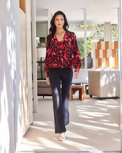 Load image into Gallery viewer, This Karen Kane top features a stylish crossover neck design and blouson sleeves. Made from high-quality fabric, it offers a relaxed fit and pullover style, perfect for both casual and formal occasions. The allover print adds a touch of elegance, making it a versatile addition to any wardrobe.