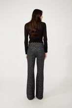 Load image into Gallery viewer, Model wearing black and silver abstract patterned pants, black turtleneck and black heels against a white background.