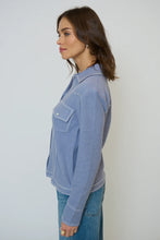 Load image into Gallery viewer, Woman wearing a light blue western style sweater top and blue jeans against a gray background.