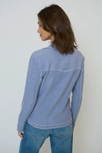 Load image into Gallery viewer, Woman wearing a light blue western style sweater top and blue jeans against a gray background.