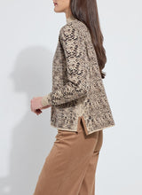Load image into Gallery viewer, Model wearing a lux camel colored snake jacquard patterned sweater and brown pants against a white background.