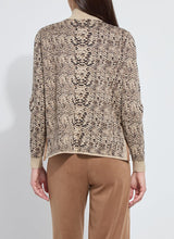 Load image into Gallery viewer, Model wearing a lux camel colored snake jacquard patterned sweater and brown pants against a white background.
