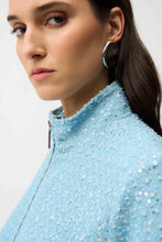 Load image into Gallery viewer, Close-up of a woman wearing a light blue sequined jacket and silver earrings against a plain background.
