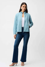 Load image into Gallery viewer, Woman wearing a sequin light blue textured jacket, blue jeans and silver heels on a white background.