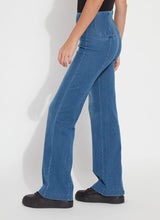 Load image into Gallery viewer, Model wearing mid wash blue denim trouser, black loafers and black top against a white background.