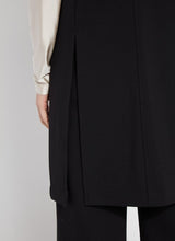 Load image into Gallery viewer, Crafted from 4-way stretch Ponte fabric, the Denver Ponte Sleeveless Coat is a classic piece ideal for the fall season. It complements the Denver Hi Waist Wide Leg Ponte pants seamlessly and is easy to maintain. The coat is sleeveless, machine washable, and fits true to size. It is designed with Lightweight Vegan Leather accents, practical pockets, elevated back slits, and a demi-belt at the back. The interior is meticulously finished with Satin binding.