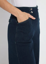 Load image into Gallery viewer, The Dion Sailor Palazzo Denim Pant is a chic sailor-inspired piece, perfect for modern fashion enthusiasts. This cropped wide-leg palazzo pant boasts trendy contrast-color topstitching and is crafted from premium 4-way stretch Knit Denim for comfort and flexibility. Featuring a clean front with a stylish waist seam, functional pockets adorned with metal buttons and eyelets, and back welt pockets, this design combines practicality with elegance.