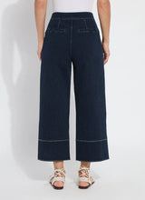 Load image into Gallery viewer, The Dion Sailor Palazzo Denim Pant is a chic sailor-inspired piece, perfect for modern fashion enthusiasts. This cropped wide-leg palazzo pant boasts trendy contrast-color topstitching and is crafted from premium 4-way stretch Knit Denim for comfort and flexibility. Featuring a clean front with a stylish waist seam, functional pockets adorned with metal buttons and eyelets, and back welt pockets, this design combines practicality with elegance.