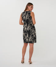 Load image into Gallery viewer, Woman wearing a black sleeveless dress with off-white floral embroidery and natural heels against a white background.