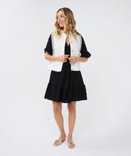 Load image into Gallery viewer, This short-sleeved dress boasts a loose fit and a floaty skirt, creating a hint of playfulness. Made from a waffle fabric, this dress is perfect for summertime, allowing for unrestricted movement and comfort.