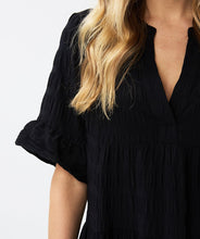 Load image into Gallery viewer, This short-sleeved dress boasts a loose fit and a floaty skirt, creating a hint of playfulness. Made from a waffle fabric, this dress is perfect for summertime, allowing for unrestricted movement and comfort.