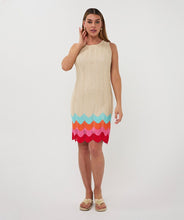 Load image into Gallery viewer, Woman wearing a beige sleeveless dress with colorful zig zag hem and tan sandals on a white background.