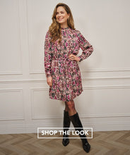 Load image into Gallery viewer, Woman wearing a zebra print dress with text 'Shop the Look' against a white paneled wall.