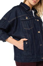Load image into Gallery viewer, Close-up of model wearing a dark denim jacket with gold buttons and her hand in the pocket.