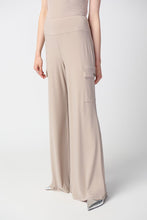 Load image into Gallery viewer, This sleek, silky knit wide-leg pant showcases a flared silhouette that effortlessly goes from day to night. Featuring a button closure and a soft contour waistband for added comfort, this look also includes cargo pockets highlighting this piece’s polished style. Color- Dune. Silky knit. Soft contour waistband. Cargo pockets. Unlined.