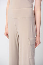 Load image into Gallery viewer, This sleek, silky knit wide-leg pant showcases a flared silhouette that effortlessly goes from day to night. Featuring a button closure and a soft contour waistband for added comfort, this look also includes cargo pockets highlighting this piece’s polished style. Color- Dune. Silky knit. Soft contour waistband. Cargo pockets. Unlined.