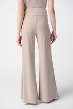 Load image into Gallery viewer, This sleek, silky knit wide-leg pant showcases a flared silhouette that effortlessly goes from day to night. Featuring a button closure and a soft contour waistband for added comfort, this look also includes cargo pockets highlighting this piece’s polished style. Color- Dune. Silky knit. Soft contour waistband. Cargo pockets. Unlined.