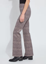 Load image into Gallery viewer, Model wearing patterned pants, black top and black boots against a white background.