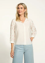 Load image into Gallery viewer, This classic white shirt is elevated with beautifully embellished 3/4-length sleeves, adding a chic and modern twist. Designed with a spread collar and crafted from 100% cotton, it offers both comfort and elegance. Perfect for pairing with tailored trousers or casual denim, this versatile piece is a must-have for any occasion.