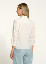 Load image into Gallery viewer, This classic white shirt is elevated with beautifully embellished 3/4-length sleeves, adding a chic and modern twist. Designed with a spread collar and crafted from 100% cotton, it offers both comfort and elegance. Perfect for pairing with tailored trousers or casual denim, this versatile piece is a must-have for any occasion.