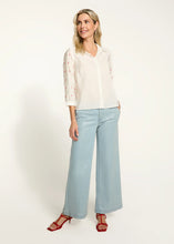 Load image into Gallery viewer, This classic white shirt is elevated with beautifully embellished 3/4-length sleeves, adding a chic and modern twist. Designed with a spread collar and crafted from 100% cotton, it offers both comfort and elegance. Perfect for pairing with tailored trousers or casual denim, this versatile piece is a must-have for any occasion.