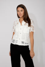 Load image into Gallery viewer, Woman wearing an off-white blouse with heart embroidery and rhinestone heart buttons and black pants against a white background.